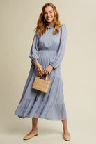 This swing dress is the perfect easy chic fall fashion. The round neckline is accented with ruffle detail for a flattering look. The long sleeves have a comfortable elastic band for a custom fit. The key hole closure on the back adds feminine flair and sleek style. The tiered bottom layer adds elegance to this piece, while the clean hem completes the look. You can easily wear this maxi dress anywhere! Avah Couture