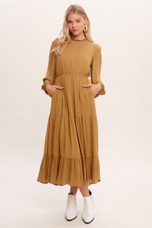 This swing dress is the perfect easy chic fall fashion. The round neckline is accented with ruffle detail for a flattering look. The long sleeves have a comfortable elastic band for a custom fit. The key hole closure on the back adds feminine flair and sleek style. The tiered bottom layer adds elegance to this piece, while the clean hem completes the look. You can easily wear this maxi dress anywhere! Avah Couture