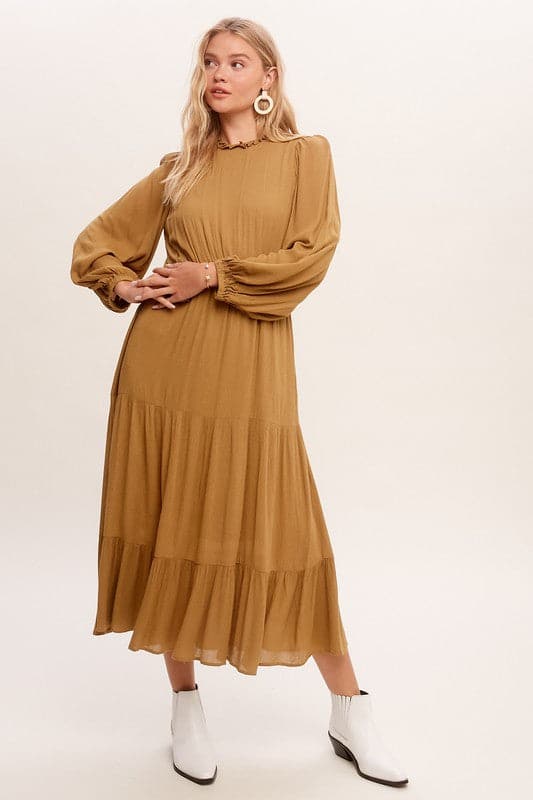 This swing dress is the perfect easy chic fall fashion. The round neckline is accented with ruffle detail for a flattering look. The long sleeves have a comfortable elastic band for a custom fit. The key hole closure on the back adds feminine flair and sleek style. The tiered bottom layer adds elegance to this piece, while the clean hem completes the look. You can easily wear this maxi dress anywhere! Avah Couture