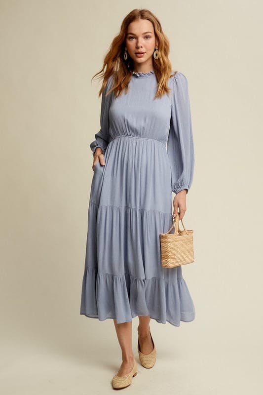 This swing dress is the perfect easy chic fall fashion. The round neckline is accented with ruffle detail for a flattering look. The long sleeves have a comfortable elastic band for a custom fit. The key hole closure on the back adds feminine flair and sleek style. The tiered bottom layer adds elegance to this piece, while the clean hem completes the look. You can easily wear this maxi dress anywhere! Avah Couture