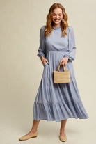 This swing dress is the perfect easy chic fall fashion. The round neckline is accented with ruffle detail for a flattering look. The long sleeves have a comfortable elastic band for a custom fit. The key hole closure on the back adds feminine flair and sleek style. The tiered bottom layer adds elegance to this piece, while the clean hem completes the look. You can easily wear this maxi dress anywhere! Avah Couture