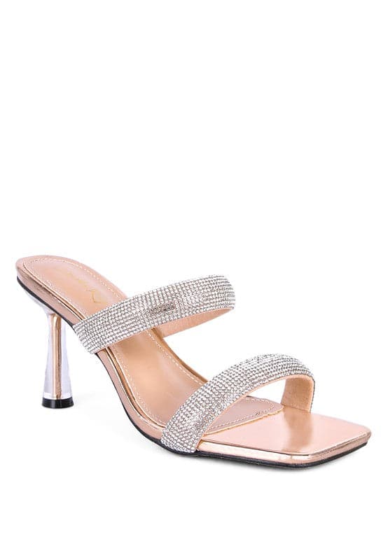 These mid heel slides are a beauty to behold. The pointed metallic heel is enclosed in clear detail, while the square toe and double strap give this shoe an air of sophistication that is accentuated by the diamanté detail. Prepare to turn heads as you walk in these beauties! Nude color. Avah Couture