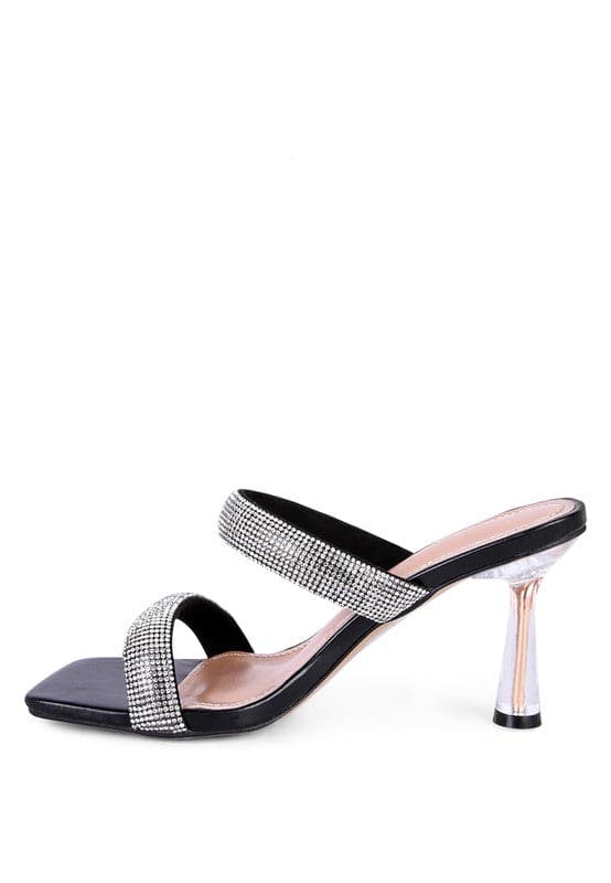 These mid heel slides are a beauty to behold. The pointed metallic heel is enclosed in clear detail, while the square toe and double strap give this shoe an air of sophistication that is accentuated by the diamanté detail. Prepare to turn heads as you walk in these beauties! Black color. Avah Couture