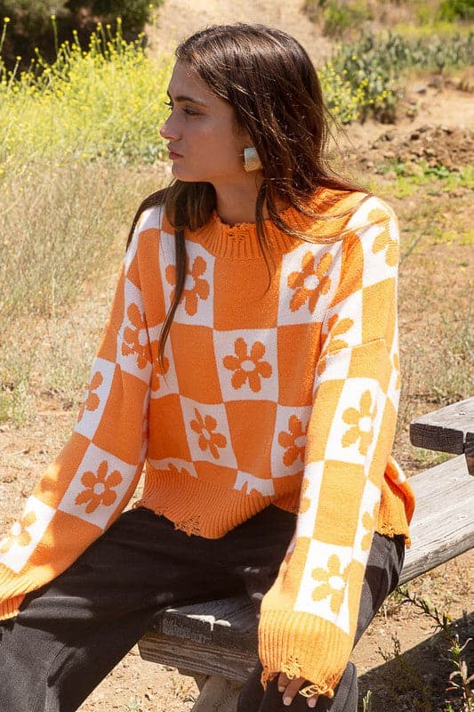 Our most popular style, this oversized sweater top is crafted with a round neckline and long sleeves for easy layering. A unique flower and checkerboard pattern creates an eye catching look. Ribbed edges add graphic detail and make it easy to pair with your favorite jeans or leggings. The irresistible oversized fit will never go out of style! Avah Couture