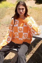 Our most popular style, this oversized sweater top is crafted with a round neckline and long sleeves for easy layering. A unique flower and checkerboard pattern creates an eye catching look. Ribbed edges add graphic detail and make it easy to pair with your favorite jeans or leggings. The irresistible oversized fit will never go out of style! Avah Couture