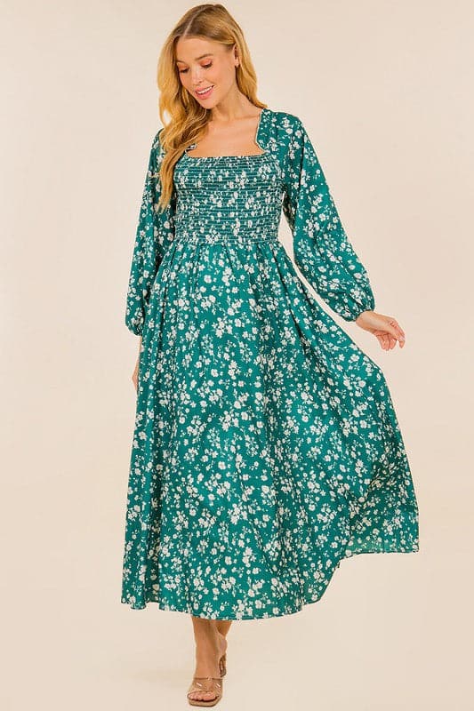 Be the flower girl in this darling full length dress. Made from a lovely floral print fabric and features a sweet square neckline and long sleeve design. This long sleeved, smocked dress has a flattering A line shape that flatters any figure. Accessorize with some cute ankle boots or strappy stilettos for a stylish look this season. Avah Couture