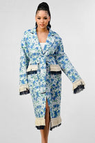 Avah Couture-Make an impact wherever you go in this feminine and trendy coat. This versatile piece is made with a beautiful blue and white floral print and will add style to any outfit. With its longline silhouette, this trench coat features a matching belt tie, button front closure, and a unique tassel fringe that decorates the hem, sleeves, and pockets.  Floral print Tassel fringe detail Collared neckline Notched lapels Belt tie Pockets Oversized fit