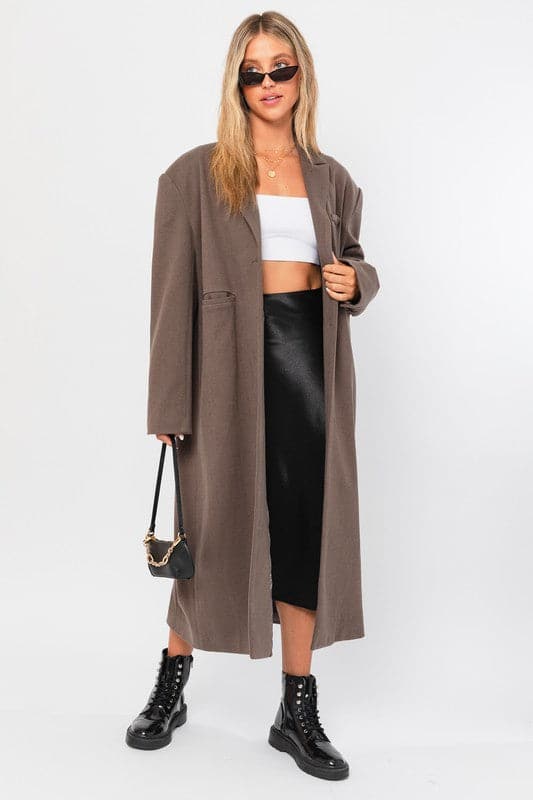 Get your 90’s groove on with this stylish and trendy long blazer coat. With its long length, two button closure, notched lapels, back vent and single welt chest pocket, it is the perfect addition to any outfit.  Avah Couture