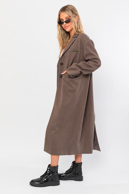 Get your 90’s groove on with this stylish and trendy long blazer coat. With its long length, two button closure, notched lapels, back vent and single welt chest pocket, it is the perfect addition to any outfit.  Avah Couture