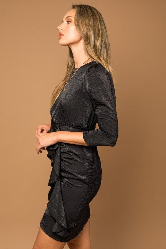 Look sophisticated and stylish in this 3/4 sleeve black dress. The ruffle detail adds a feminine touch and the keyhole button back is eye catching. This chic empire waist satin dress will look amazing with your favorite heels or flats. Avah Couture