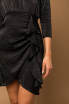 Look sophisticated and stylish in this 3/4 sleeve black dress. The ruffle detail adds a feminine touch and the keyhole button back is eye catching. This chic empire waist satin dress will look amazing with your favorite heels or flats. Avah Couture