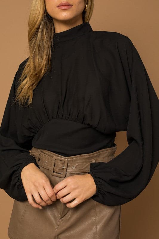 This black top is the quintessential piece for any fashion savvy closet. The chic top features a mock neck, dramatic dolman long sleeves, fitted bottom and double button keyhole back. Wear with your favorite jeans or vegan leather pants for the perfect everyday look. Avah Couture