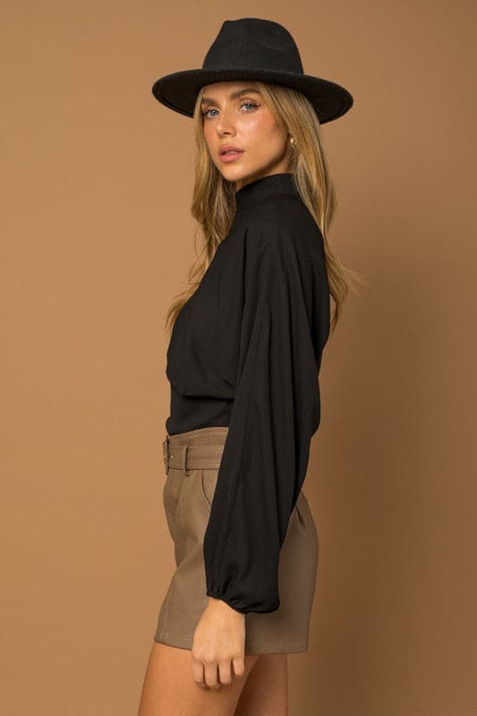 This black top is the quintessential piece for any fashion savvy closet. The chic top features a mock neck, dramatic dolman long sleeves, fitted bottom and double button keyhole back. Wear with your favorite jeans or vegan leather pants for the perfect everyday look. Avah Couture