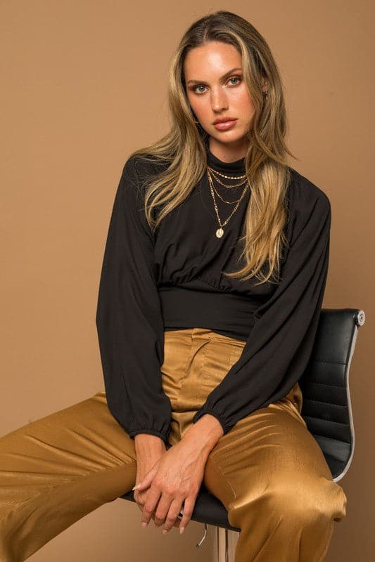 This black top is the quintessential piece for any fashion savvy closet. The chic top features a mock neck, dramatic dolman long sleeves, fitted bottom and double button keyhole back. Wear with your favorite jeans or vegan leather pants for the perfect everyday look. Avah Couture