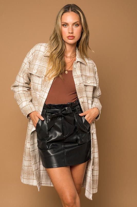This stylish shirt jacket is the perfect outerwear for every day. The jacket has front pockets and side slant pockets for added style. A casual cut adds a fun, trendy look to this classic long shacket that goes with everything from jeans too dresses. Avah Couture