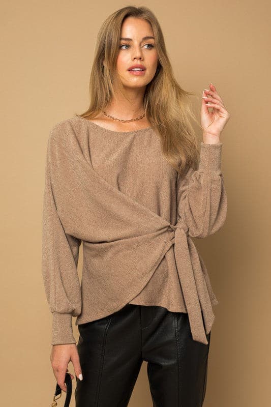 Wrap and tie it up! This fashionable top features a dolman sleeve, wrap front with tie, and boat neckline. Pair it with your favorite vegan leather pants or skirt for an effortlessly chic look.  Avah Couture