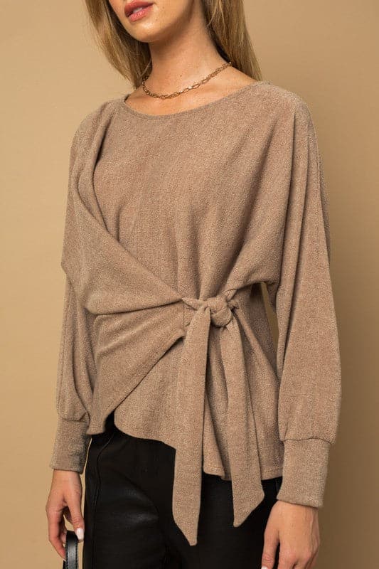 Wrap and tie it up! This fashionable top features a dolman sleeve, wrap front with tie, and boat neckline. Pair it with your favorite vegan leather pants or skirt for an effortlessly chic look.  Avah Couture