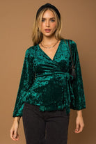 This wrap front velvet top is perfect for your next holiday party. This long sleeve top features a wrap front with waist tie that is sure to add some style to your look! Avah Couture