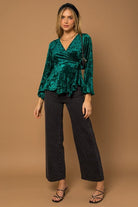 This wrap front velvet top is perfect for your next holiday party. This long sleeve top features a wrap front with waist tie that is sure to add some style to your look! Avah Couture