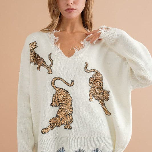 You’ll love this fun, edgy sweater. It’s the perfect way to express your wild side! This v-neck, pullover sweater features sequin tigers and frayed edges, making it the perfect top for weekend outings and casual get-togethers - Avah Couture