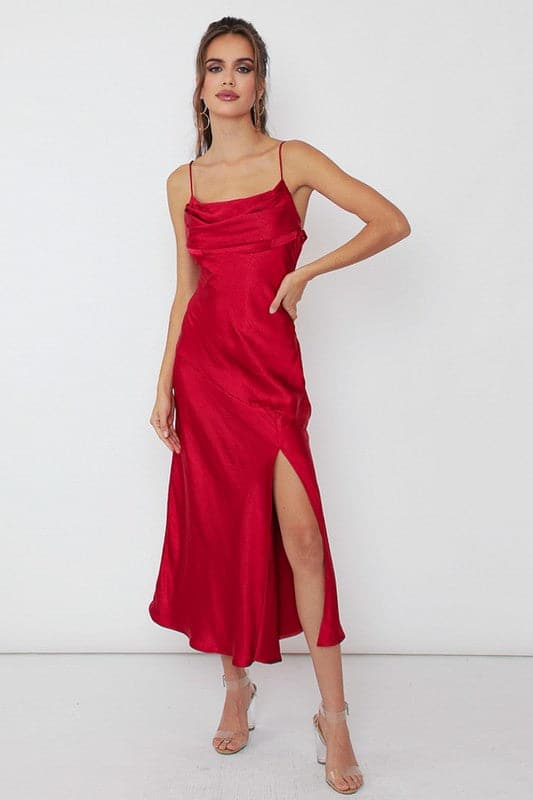 Take the plunge in this stunning dress that is sure to make a statement. This satin side slit midi dress has draped cami detailing and a fitted silhouette, accented with a side slit and small cowl front. This slip dress is sure to take your style to the next level. Pair it with red heels for a striking look - Avah Couture