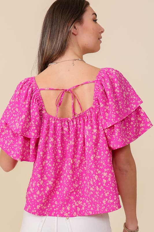 Avah Couture- Make a sweet impression in this smocked square neck blouse covered in delightful blooms. This fuchsia floral top has a self-tie open back and short sleeves accented with ruffles. Embrace the phenomenal florals of spring.  Floral print Smocked square neck Ruffle short sleeves Open back with self-tie Short length- Fuchsia Pink 