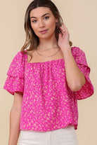 Avah Couture- Make a sweet impression in this smocked square neck blouse covered in delightful blooms. This fuchsia floral top has a self-tie open back and short sleeves accented with ruffles. Embrace the phenomenal florals of spring.  Floral print Smocked square neck Ruffle short sleeves Open back with self-tie Short length- Fuchsia Pink 