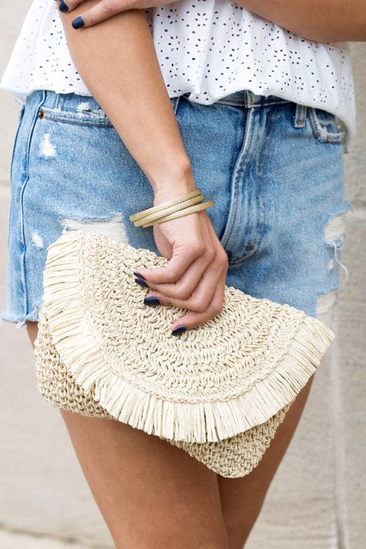 This perfectly sized straw clutch has an airy, casual feel, making it a great everyday option. The frayed edge detail adds a touch of whimsy to this functional piece. The interior is lined and includes a sidewall pocket and a zip pocket.  Fold over Clasp closure Straw exterior Cotton linen lining Frayed detail Interior sidewall Zip pocket