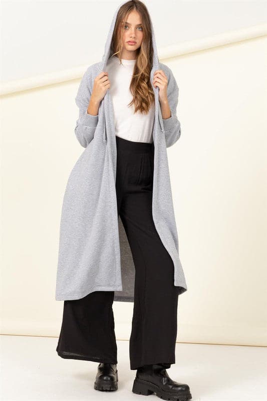 Elevate your look with this trendy terry coat! Featuring a hooded neckline, drop shoulders and relaxed long sleeves with fitted cuffs. The longline silhouette flatters your figure by emphasizing a tall silhouette and drawing attention to the length. The open front design makes it easy to wear over everyday outfits for added warmth without sacrificing style. Avah Couture