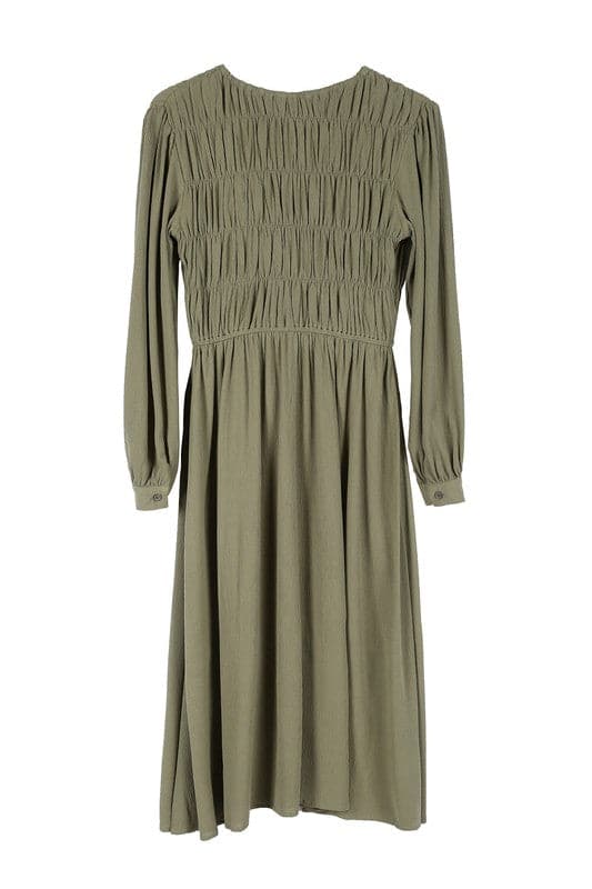 This beautiful midi dresses has four tiers of elastic bands at the bodice which creates a lovely ruched effect. This design gives it an elegant and feminine appearance. The All Dressed Up Ruched Midi Dress has a boat neckline, long sleeves with button at each cuff and below the knee length for easy transition into fall. Wear it with heels and a clutch bag for a chic look. This dress is lined.  