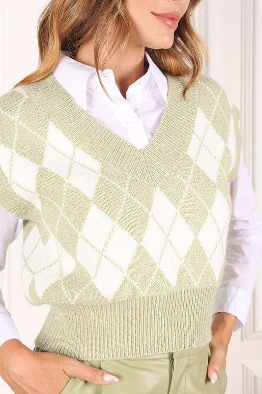 A knitted vest is a must have for fall and winter, and this version features an argyle pattern and V neckline to add some interest. It's sleeveless so you can wear it alone or layered over a button down shirt or tank. Green color. Avah Couture