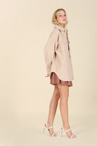 This contemporary light beige shacket is a perfect piece to add to your stylish wardrobe. Style with your favorite jeans and boots, or wear it with a pencil skirt and heels for an impeccable office look. Features collared neckline, button front, two chest pockets, long sleeves and single button at the cuff. Avah Couture