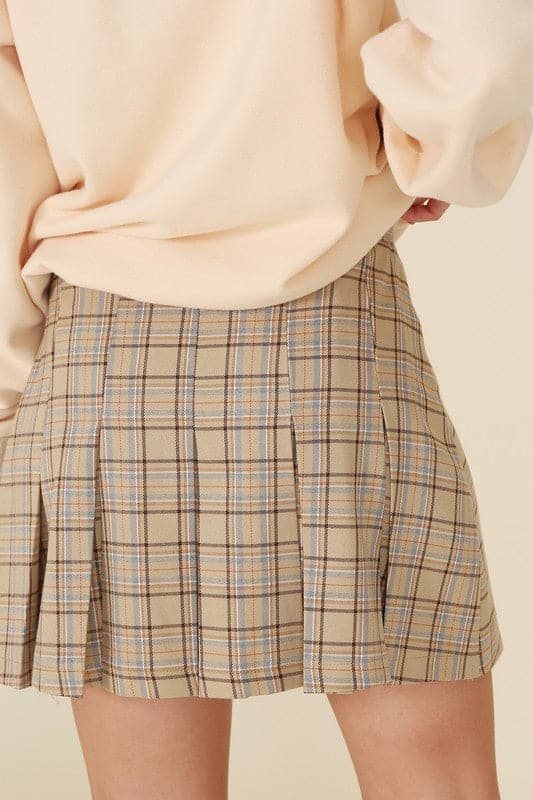 What fun fall will bring with the Baby Baby Plaid Pleated Mini Skirt! Features 6 pin tucks for each front and back and a side zipper. Style with a blouse or sweater with knee high boots, loafers or heels for a fun on trend fall look.  