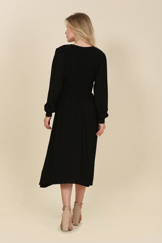 This beautiful midi dresses has four tiers of elastic bands at the bodice which creates a lovely ruched effect. This design gives it an elegant and feminine appearance. The All Dressed Up Ruched Midi Dress has a boat neckline, long sleeves with button at each cuff and below the knee length for easy transition into fall. Wear it with heels and a clutch bag for a chic look. This dress is lined.  