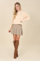 What fun fall will bring with the Baby Baby Plaid Pleated Mini Skirt! Features 6 pin tucks for each front and back and a side zipper. Style with a blouse or sweater with knee high boots, loafers or heels for a fun on trend fall look.  