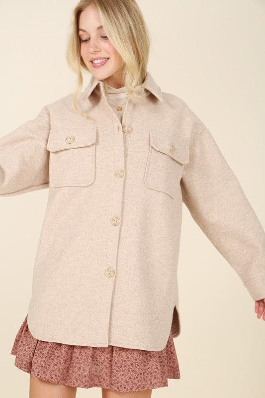 This contemporary light beige shacket is a perfect piece to add to your stylish wardrobe. Style with your favorite jeans and boots, or wear it with a pencil skirt and heels for an impeccable office look. Features collared neckline, button front, two chest pockets, long sleeves and single button at the cuff. Avah Couture