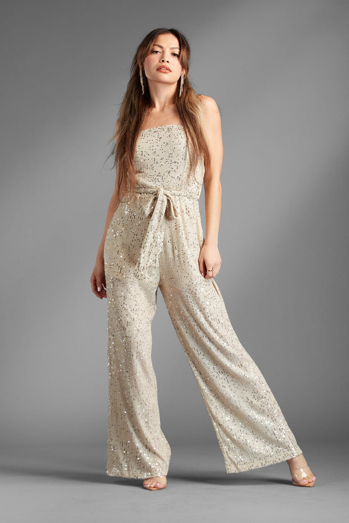 Our Brooke Gold Sequin Strapless Jumpsuit is everything you’re craving in a fun and flirty piece. The gold sequin is the perfect solution for a night out on the town or anytime you want to let your inner sparkle out! Features a strapless bodice, tie belt at the waist, and a semi-sheer leg. This sequin jumpsuit is the ultimate in fun and trendy sparkle. Avah Couture