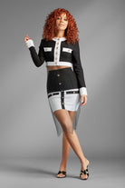 Feel like a queen in sheer elegance with the Revealed for Glory Two-Piece skirt suit. (Metal Mesh Rhinestone Overlay Sold Separately)  You'll look regal in this white and black bandage top jacket and mini skirt. In addition to being a fierce fashion statement, the thick stretch material of this set allows for the most flattering fit while the gold buttons and decorative pockets add a touch of sophisticated style. Wear it as a set or split it up, the possibilities are endless. Avah Couture