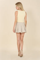 Alexis Pleated Vegan Leather Mini Skirt - Ivory. This vegan leather pleated mini skirt is made of high quality faux leather. The skirt has four pin tucks for each front and back and a side zipper closure. The Alexis Pleated Vegan Mini Skirt will make your legs look longer and slimmer and pairs perfectly with a blouse for work or play! 