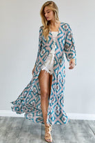 Model in teal duster walking forward, showing motion and lightweight fabric – AVAH