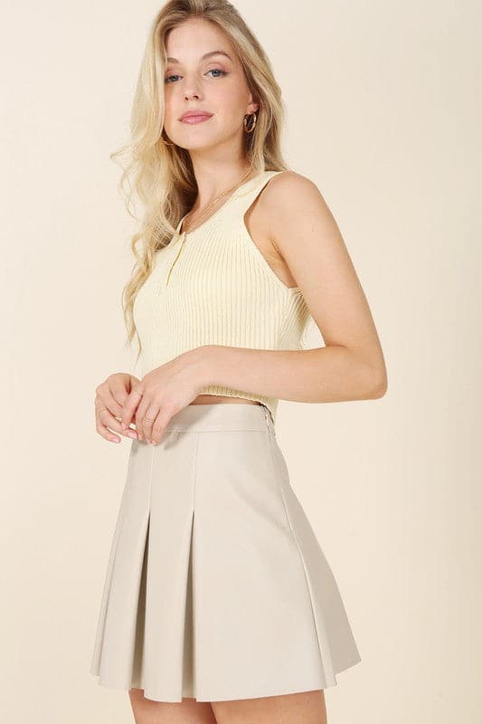 Alexis Pleated Vegan Leather Mini Skirt - Ivory. This vegan leather pleated mini skirt is made of high quality faux leather. The skirt has four pin tucks for each front and back and a side zipper closure. The Alexis Pleated Vegan Mini Skirt will make your legs look longer and slimmer and pairs perfectly with a blouse for work or play! 