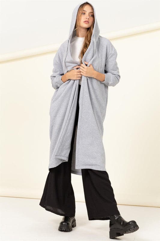 Elevate your look with this trendy terry coat! Featuring a hooded neckline, drop shoulders and relaxed long sleeves with fitted cuffs. The longline silhouette flatters your figure by emphasizing a tall silhouette and drawing attention to the length. The open front design makes it easy to wear over everyday outfits for added warmth without sacrificing style. Avah Couture
